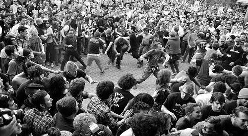 Dichte Konzertmenge mit ausgelassenem Moshpit in Schwarz-Weiß
